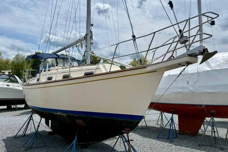 Slide: The Image of 1992 Island Packet 29 sailboat on stands, displayed outdoors under cloudy sky. - 1