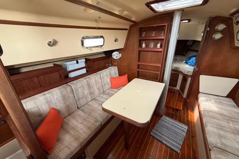 Slide: The Image of Interior of 1992 Island Packet 29 sailboat with cozy seating and wooden accents. - 10