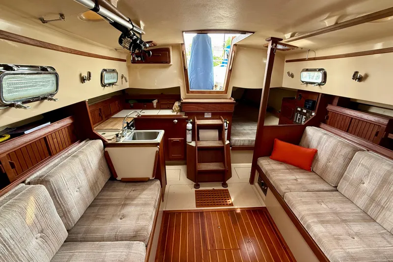 Slide: The Image of Interior of 1992 Island Packet 29 sailboat with cozy seating and compact kitchen. - 11