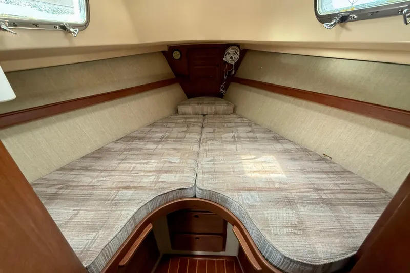 Slide: The Image of Cozy cabin interior of 1992 Island Packet 29 sailboat with comfortable bedding and wooden accents. - 16