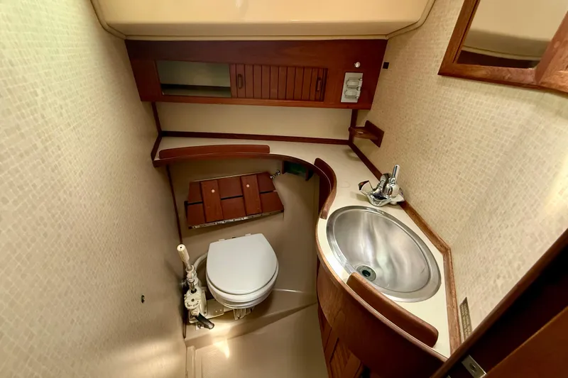 Slide: The Image of Compact bathroom in a 1992 Island Packet 29 sailboat, featuring a toilet and stainless steel sink. - 17