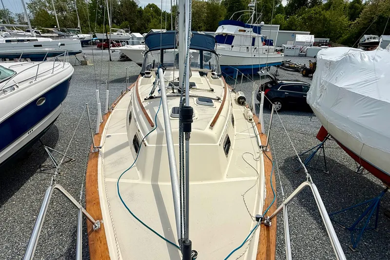 Slide: The Image of 1992 Island Packet 29 sailboat on dry dock, surrounded by other boats and vehicles. - 5