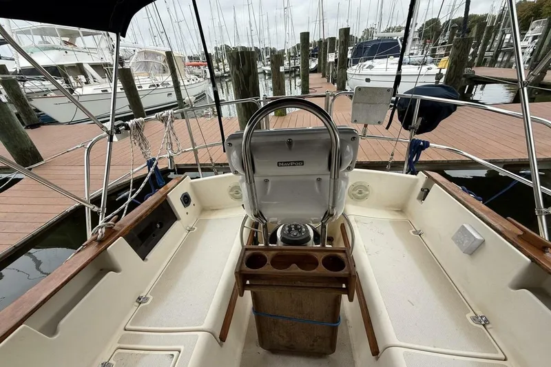 Slide: The Image of 1992 Island Packet 29 sailboat cockpit with steering wheel, docked at marina. - 8
