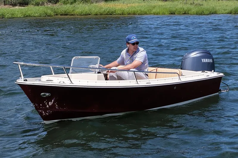 Slide: The Image of Man piloting a 2027 Rossiter 14 boat with Yamaha engine on a sunny day. - 5