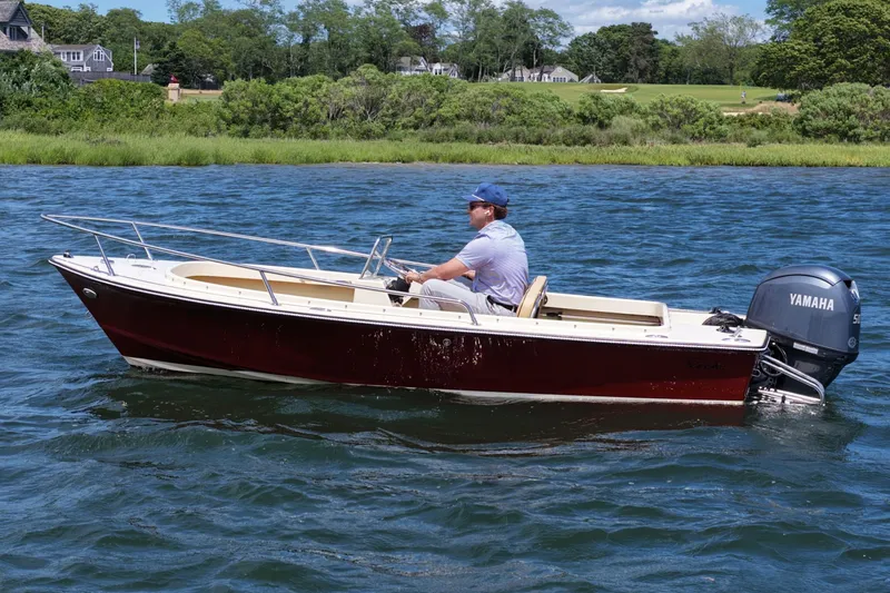 Slide: The Image of Man driving a 2027 Rossiter 14 boat with Yamaha engine on a scenic lake. - 4