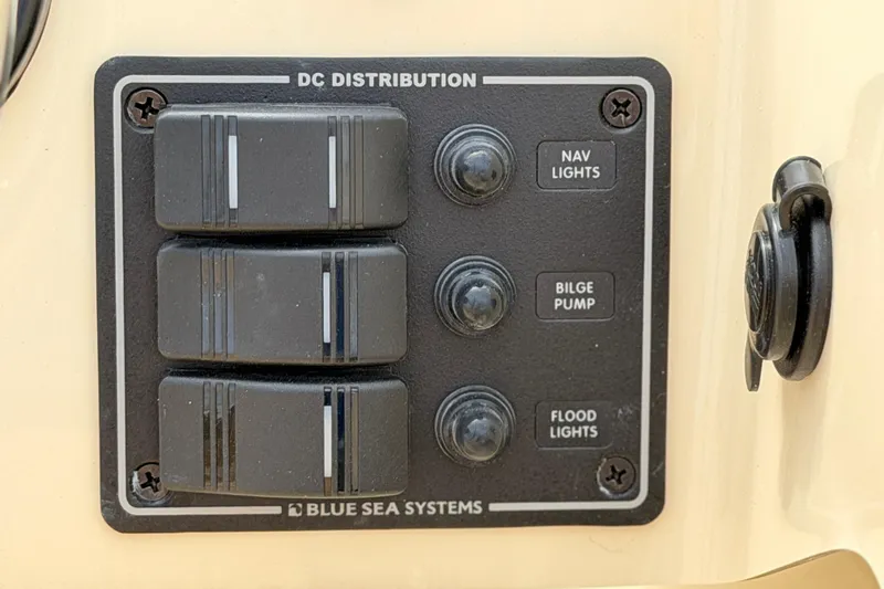Slide: The Image of DC distribution panel on Rossiter 14, 2027 model, featuring switches for nav lights, bilge pump, flood lights. - 24