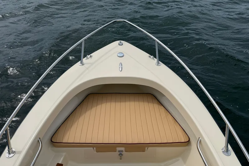 Slide: The Image of Bow view of 2027 Rossiter 14 boat with tan seating on water. - 29