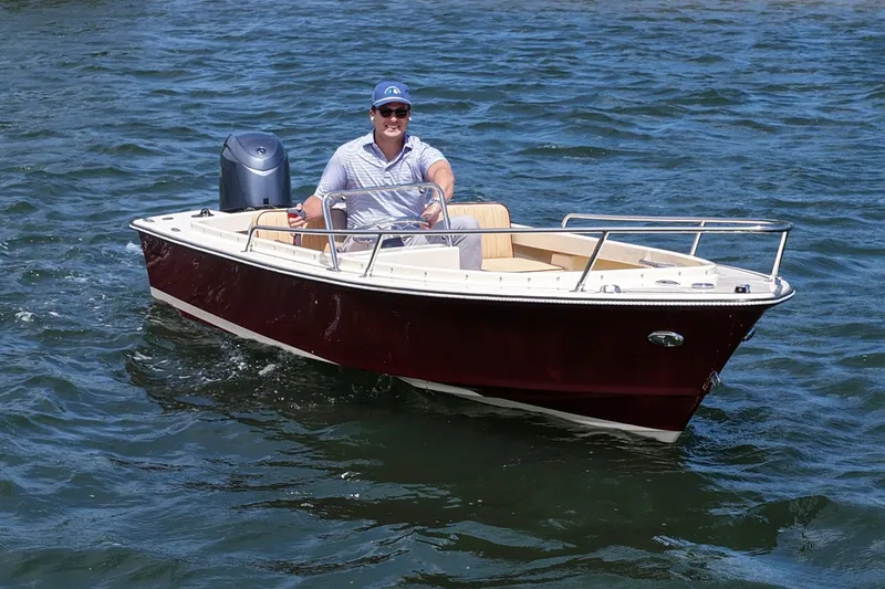 Slide: The Image of Man piloting a 2027 Rossiter 14 boat on open water. - 7