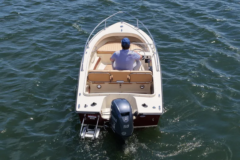 Slide: The Image of A person navigates a 2027 Rossiter 14 boat on open water. - 9