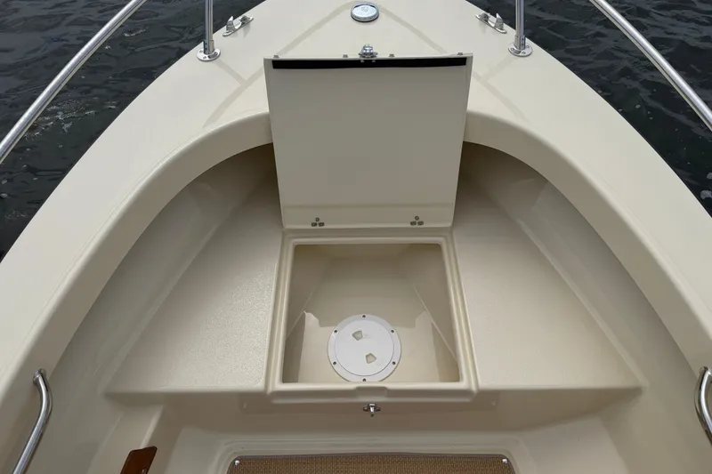 Slide: The Image of 2027 Rossiter 14 boat interior with storage compartment, beige finish, and stainless steel railings. - 31