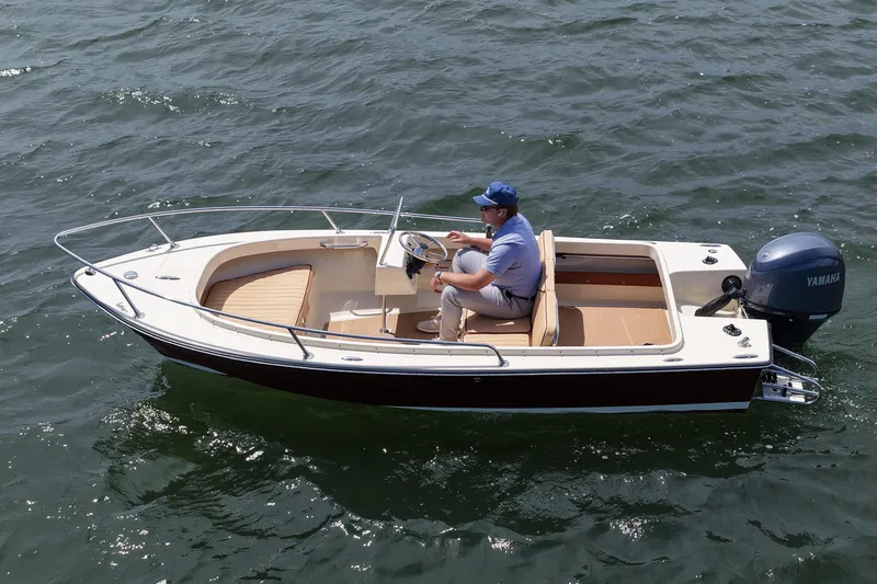 Slide: The Image of Man piloting a 2027 Rossiter 14 boat on open water. - 8