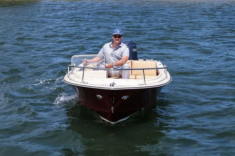 Slide: The Image of Man piloting a 2027 Rossiter 14 boat on a sunny day. - 6