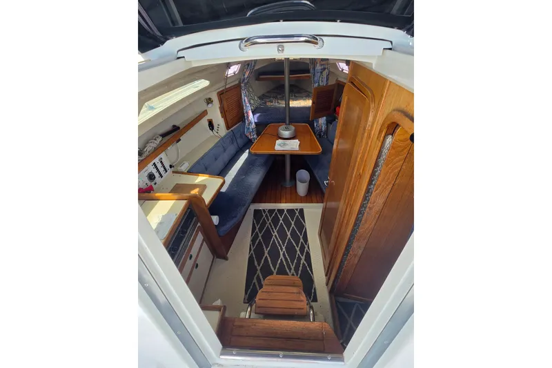 Slide: The Image of Interior of a 1999 Catalina 270 sailboat with wooden furnishings and cozy seating. - 12