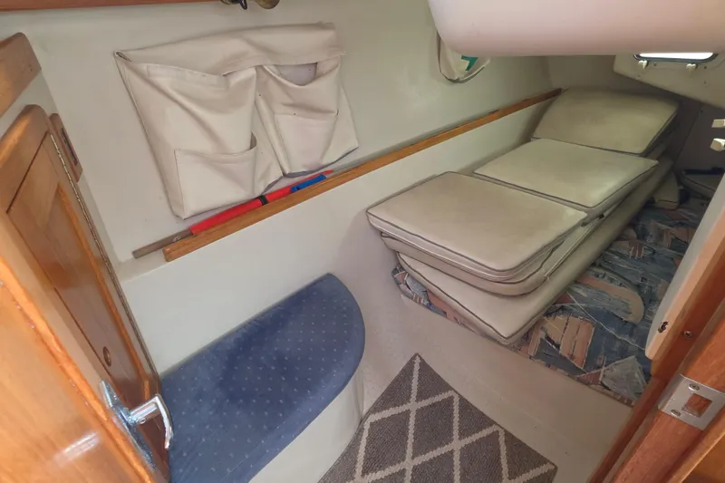 Slide: The Image of 1999 Catalina 270 sailboat interior with cushions and storage pockets. - 18