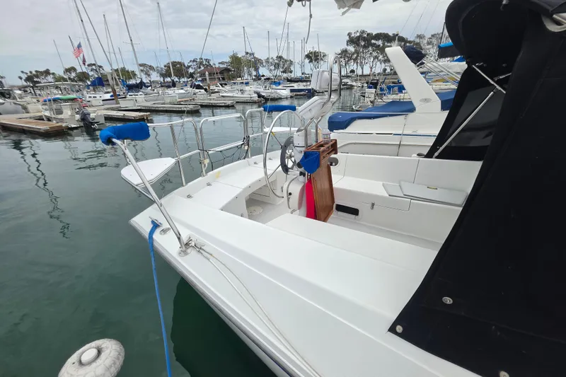 Slide: The Image of 1999 Catalina 270 sailboat docked in a marina, surrounded by other boats. - 6