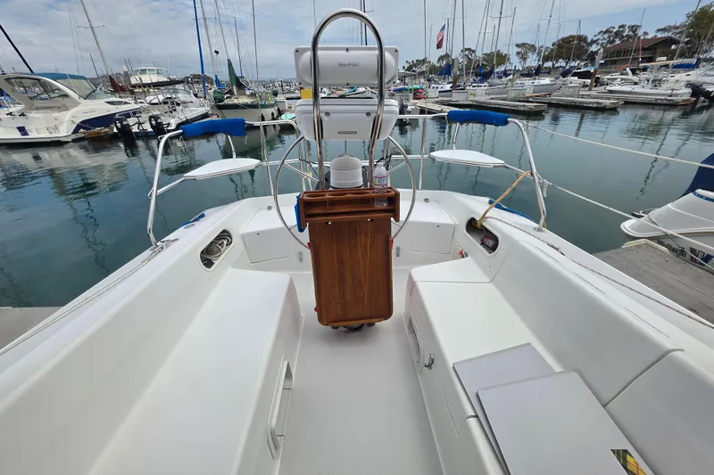 Slide: The Image of 1999 Catalina 270 sailboat cockpit view in marina, showcasing helm and seating area. - 8