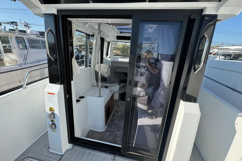 Slide: The Image of 2026 Jeanneau NC Sport 795 Series 2 boat interior with sliding glass door and seating area. - 10