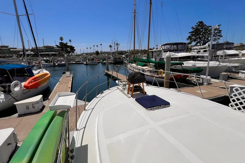 Slide: The Image of 1985 Heritage East 40 Sundeck Trawler docked in a sunny marina with sailboats. - 13