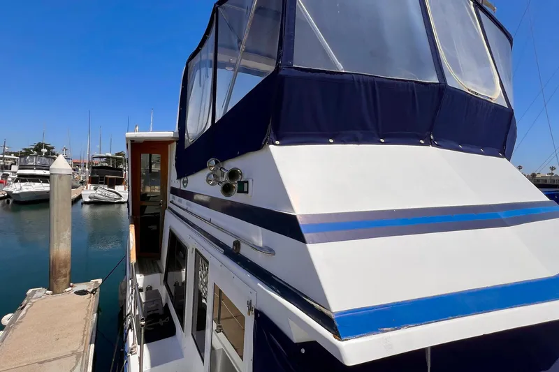 Slide: The Image of 1985 Heritage East 40 Sundeck Trawler docked at marina under clear blue sky. - 14