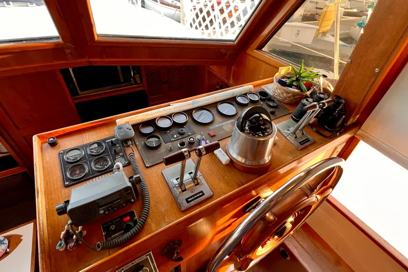Slide: The Image of 1985 Heritage East 40 Sundeck Trawler helm with gauges, controls, and wooden steering wheel. - 18