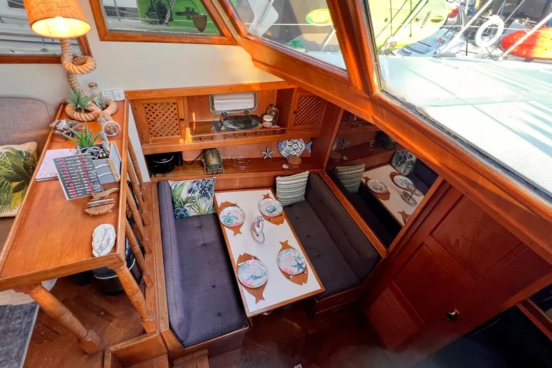 Slide: The Image of 1985 Heritage East 40 Sundeck interior with cozy dining area and nautical decor. - 21