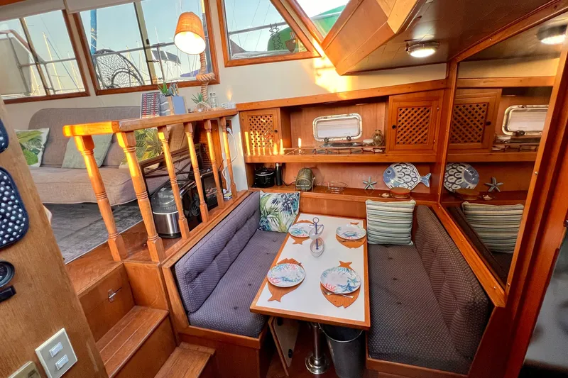 Slide: The Image of Interior of 1985 Heritage East 40 Sundeck Trawler with cozy dining area and nautical decor. - 24