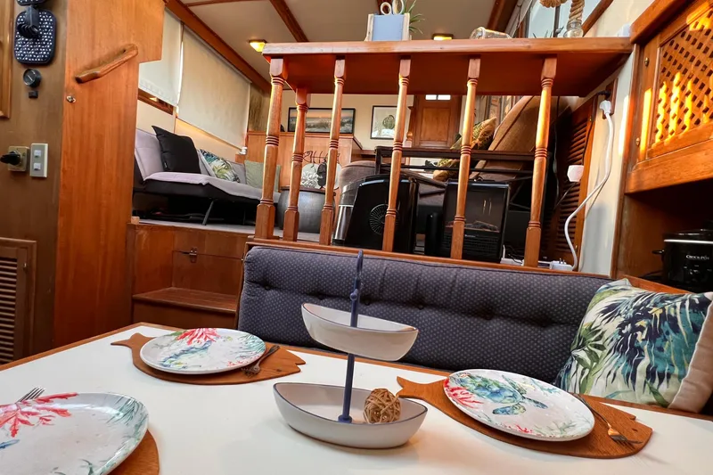Slide: The Image of Interior of 1985 Heritage East 40 Sundeck Trawler with cozy dining area and decorative plates. - 25