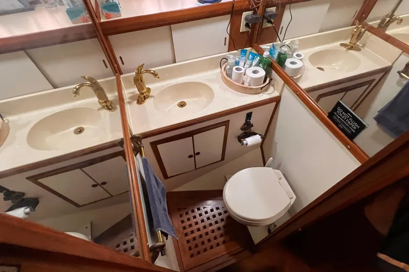 Slide: The Image of 1985 Heritage East 40 Sundeck bathroom with dual sinks, gold faucets, and wooden cabinetry. - 29