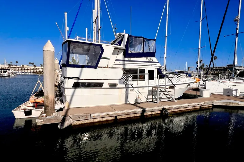 Slide: The Image of 1985 Heritage East 40 Sundeck Trawler docked at marina under clear blue sky. - 4