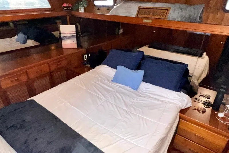 Slide: The Image of Cozy bedroom in 1985 Heritage East 40 Sundeck trawler with wood accents and blue bedding. - 48