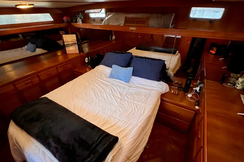 Slide: The Image of Cozy bedroom in 1985 Heritage East 40 Sundeck yacht with wood paneling and ample storage. - 49