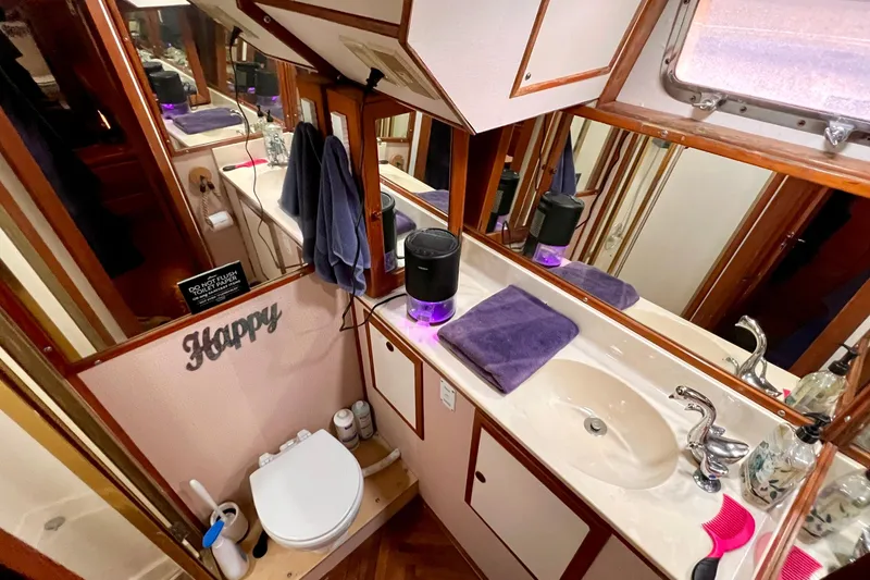 Slide: The Image of Bathroom interior of 1985 Heritage East 40 Sundeck Trawler, featuring sink, mirror, and toilet. - 53