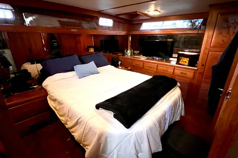 Slide: The Image of Cozy bedroom in 1985 Heritage East 40 Sundeck yacht, featuring wood paneling and modern amenities. - 54