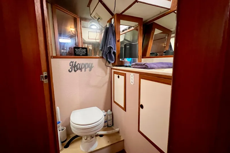 Slide: The Image of 1985 Heritage East 40 Sundeck bathroom with toilet, mirror, and storage cabinets. - 56