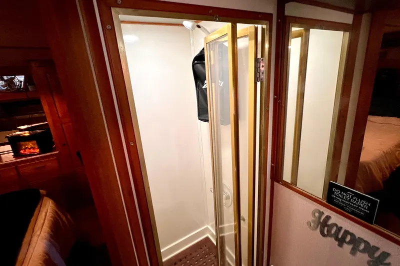 Slide: The Image of Shower area in 1985 Heritage East 40 Sundeck trawler, featuring wooden trim and glass door. - 57