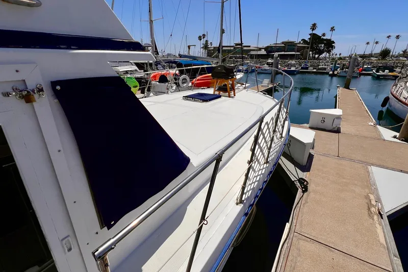 Slide: The Image of 1985 Heritage East 40 Sundeck Trawler docked at marina under clear blue sky. - 6