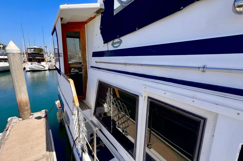 Slide: The Image of 1985 Heritage East 40 Sundeck Trawler docked at marina, showcasing aft cabin design. - 7