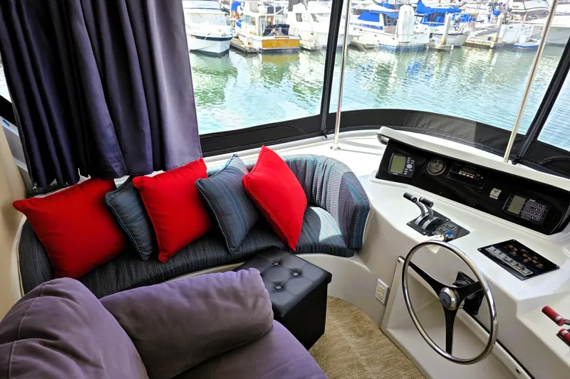 Slide: The Image of Cozy interior of 1991 Bluewater Yachts 5900 Coastal Cruiser with helm and colorful cushions. - 14