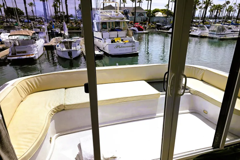 Slide: The Image of 1991 Bluewater Yachts 5900 Coastal Cruiser with spacious deck seating in a marina. - 15
