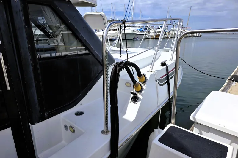Slide: The Image of 1991 Bluewater Yachts 5900 Coastal Cruiser docked at marina, showcasing sleek design. - 24