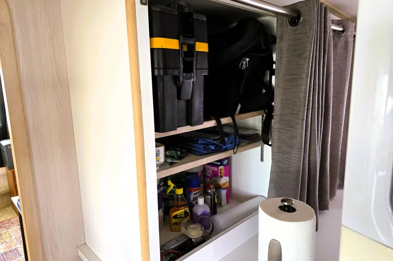 Slide: The Image of Storage cabinet on a 1991 Bluewater Yachts 5900 Coastal Cruiser, containing tools and cleaning supplies. - 27