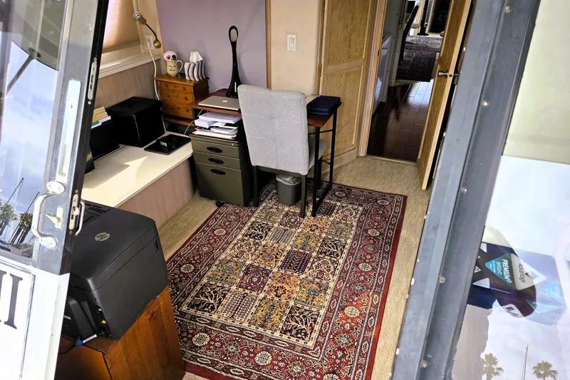 Slide: The Image of Interior of 1991 Bluewater Yachts 5900 Coastal Cruiser with office setup and decorative rug. - 31