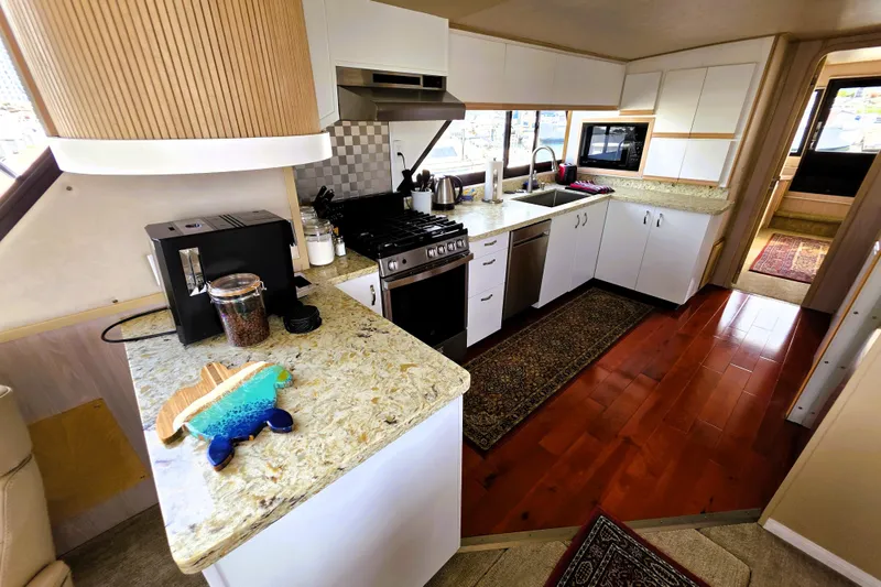 Slide: The Image of Spacious kitchen in 1991 Bluewater Yachts 5900 Coastal Cruiser with modern appliances and wood flooring. - 4