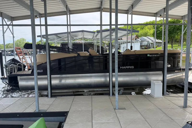 The Image of 2023 Harris Cruiser 250 CW pontoon boat docked under a covered marina. - 1