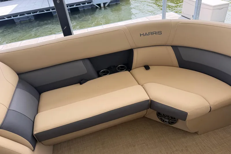 Slide: The Image of 2023 Harris Cruiser 250 CW boat interior with beige and gray seating by the water. - 20