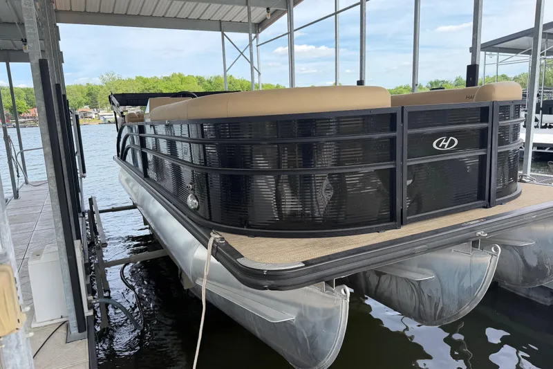 Slide: The Image of 2023 Harris Cruiser 250 CW pontoon boat docked under a covered marina. - 3