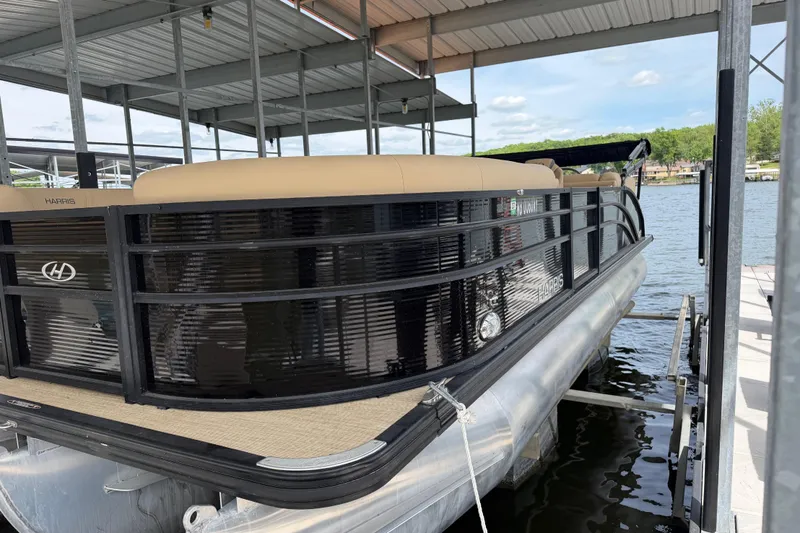 Slide: The Image of 2023 Harris Cruiser 250 CW pontoon boat docked under a covered marina. - 5