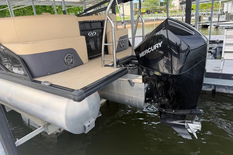 Slide: The Image of 2023 Harris Cruiser 250 CW pontoon boat with Mercury outboard motor docked at marina. - 8