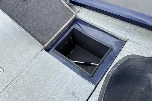 Slide: The Image of 2017 G3 Sportsman 1710 Vinyl boat storage compartment with open lid and visible tool. - 33