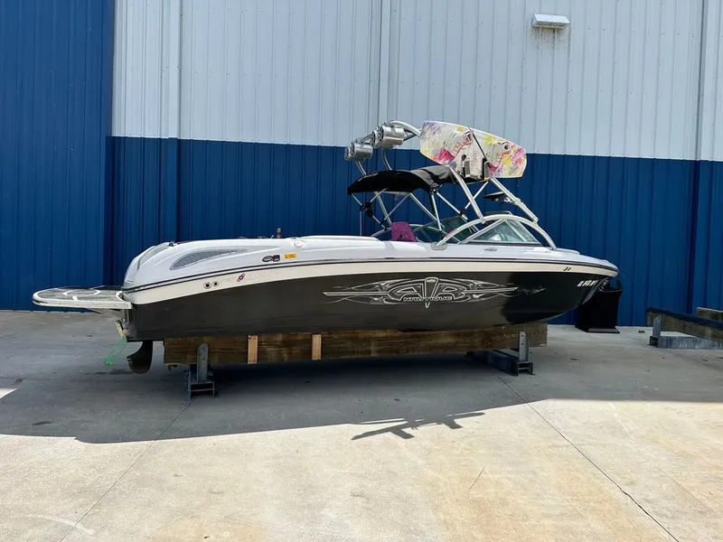 Slide: The Image of 2007 Nautique 211 boat on a dock in front of blue building. - 18
